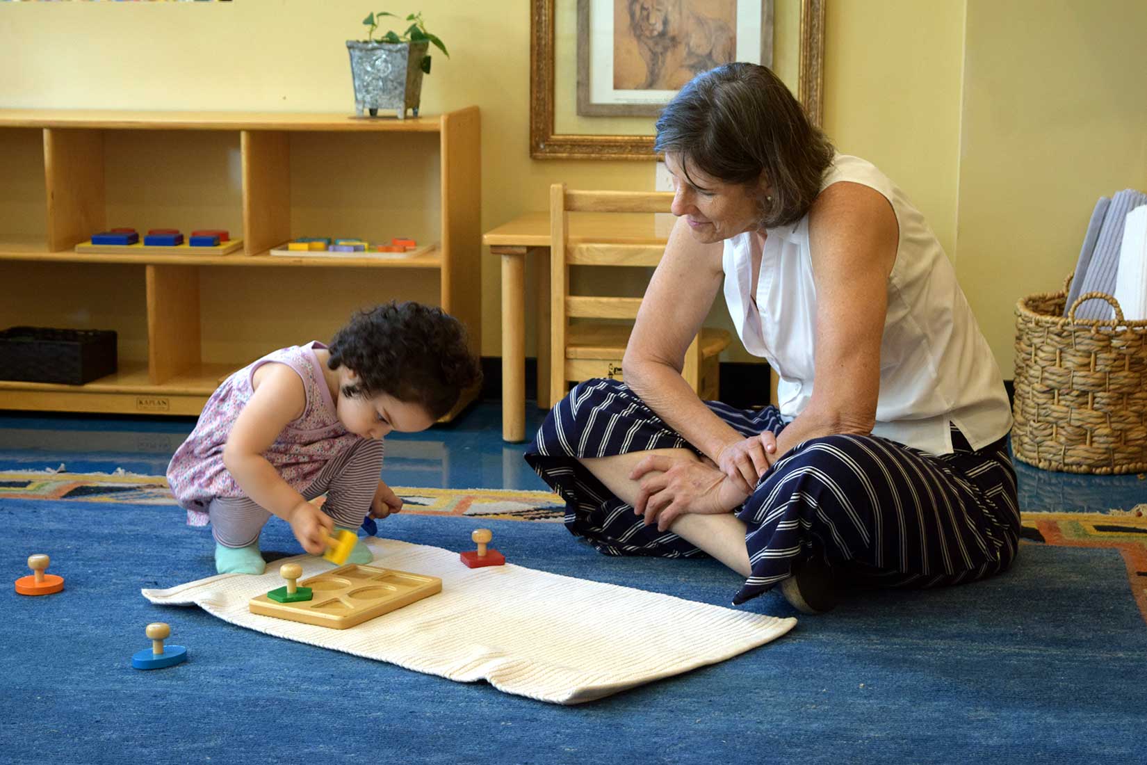 a teacher watches a child work